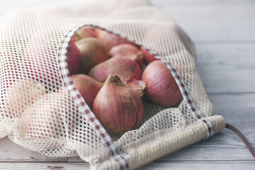 fresh onion in a reusable shopping bag 