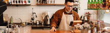 Adult Asian Man Standing By Cash Register While Working In Cafe