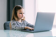 © F8  \ Suport Ukraine - Little girl learning English indoors at online lesson on laptop
