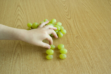 Grapes photography and a child hand. Healthy food concept.