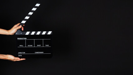 Wall Mural - Hand's holding Clapperboard or movie slate use in video production ,film, cinema industry on black background.