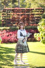 A beautiful woman in lolita dress in garden background Japanese street fashion portrait