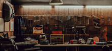 Workshop Scene. Old Tools Hanging On Wall In Workshop, Tool Shelf Against A Table And Wall, Vintage Garage Style