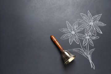 Wall Mural - Golden bell and drawn flowers on black chalkboard, top view. School days