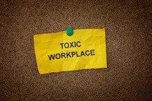 A Crumpled Sticky Note With The Words Toxic Workplace On It Pinned To A Cork Board