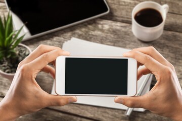 Sticker - Human holding a smartphone with  screen on table. Office environment.