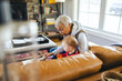 © Lisa Weatherbee - Asian grandmother reads a book to her mixed race granddaughter while sitting together on the couch