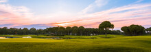 Panoramic View Of Beautiful Golf Course With Pines At Sunset. Golf Field With Fairway, Green, Hole, Flag And Lake