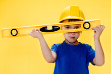 The Preschooler In A Helmet With A Construction Level Plays A Builder