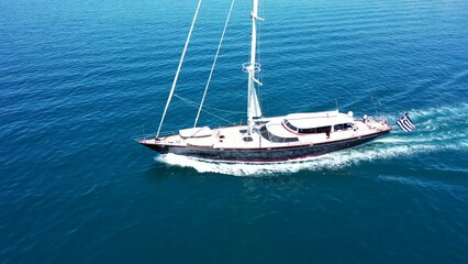 Wall Mural - Aerial drone tracking video of beautiful sailboat cruising in deep blue Aegean sea, Greece