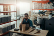© Friends Stock - Business owner of small coffee roasting factory talking phone on his workplace