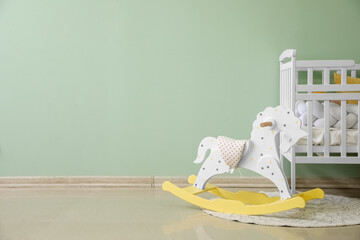 Sticker - Baby crib and rocking horse near green wall