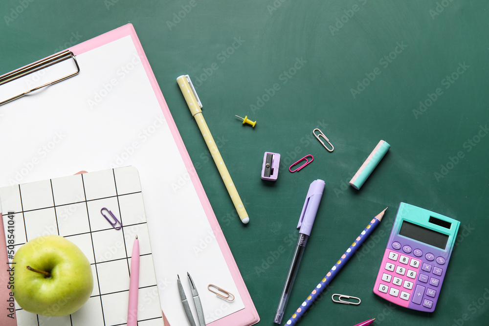 School stationery with apple on green chalkboard