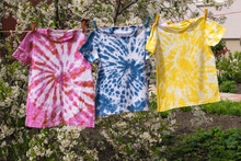 Drying Three Multi-colored T-shirts In Tie Dye Style.