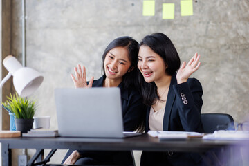 asian young businesswoman attending video conference on laptop computer online co worker leaning at 