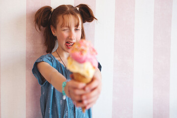 Wall Mural - Cute little girl eating ice cream in cafeteria. Child holding icecream. Kid and sweets