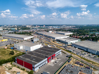 Huge warehouse building with flat roof and cars near city