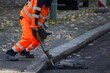 Bauarbeiter mit Presslufthammer bricht Asphaltdecke auf