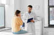 © Syda Productions - medicine, healthcare and people concept - male doctor with clipboard talking to scared or coughing woman patient at hospital