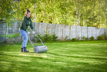 Woman Working With Lawn Roller In The Garden