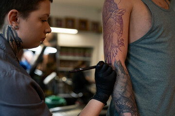 Sticker - Adult caucasian artist checking the sketch on the body