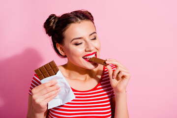 Wall Mural - portrait of peaceful pretty person closed eyes enjoy taste milk chocolate isolated on pink color bac