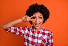 Photo Of Adorable Exited Woman Wear Plaid Shirt Showing V-sign Cover Eye Isolated Orange Color Background