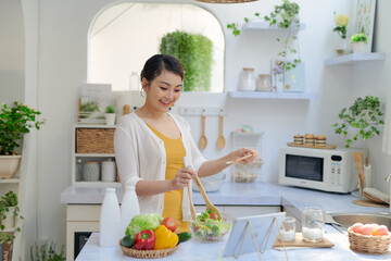 Wall Mural - Young woman cooking in the kitchen