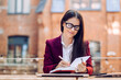 © Iona - Gorgeous brunette in glasses writing her plans in her notebook while sitting at the table with diary. Business and management concept.