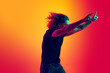 © master1305 - Rock music fan. Astonished man with long curly hair dancing isolated on gradient yellow red background in neon. Concept of beauty, fashion, youth, music and emotions