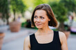 © Iona - Gorgeous young woman with short hair dressed casual looking aside with confidence and pretty smile walking in park. Girl satisfied with her lifestyle, fitness and her job. Success people concept.