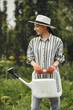 Women pours flowers in the garden with watering can
