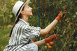 Woman in a hat gardening in her backyard