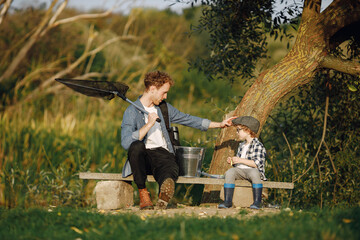 Wall Mural - Young father teaching his little toddler son how to fish