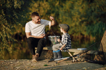 Wall Mural - Young father teaching his little toddler son how to fish