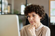 © pressmaster - Young businesswoman in eyeglasses thinking about new ideas during her work on computer at office