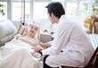 © Chalermphon - Asian Doctor Talking With Senior Female Patient In Bed At Home.Paliative care for Elder woman at home.Elderly senior patient (Asian old aging person) in nursing hospice  holding geriatrician doctor.