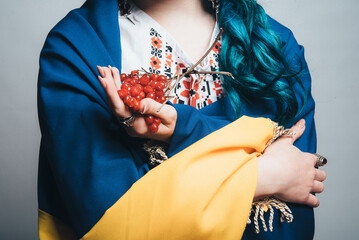 viburnum in the hands of a Ukrainian girl close-up. white embroidery. photo in studio on a white background with a flag on his shoulders