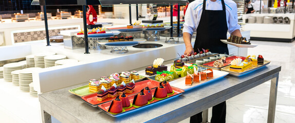 Wall Mural - Serving staff sweet table pastries and cakes in the hotel bar