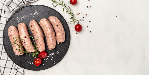 Wall Mural - Raw sausages with herbs and spices on a light background. Ketogenic diet, Long banner format. top view