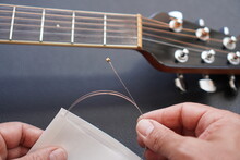 Caucasian Man Changes Acoustic Guitar String