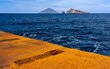 Liparische Inseln, die besondere Insel PANAREA: der Hafen mit rostigem Kai und dem blauen Meer, im Hintergrund Stromboli