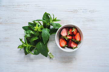 Wall Mural - Fresh organic local herb and berry fruit. Sliced strawberries and mint