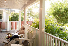 Woman Relaxing In Chair On Porch