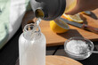 Cooking fresh homemade isotonic from natural ingredients - salt, lemon and mineral water. Pouring into a bottle