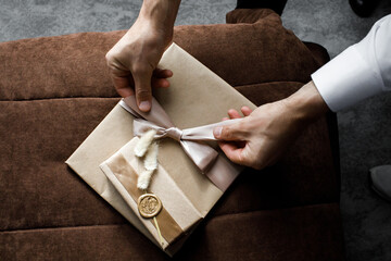 The groom opens a gift from the bride