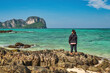 © Noppasinw - Tropical islands view with woman tourist looking at ocean blue sea water and white sand beach at Bamboo Island, Krabi Thailand nature landscape