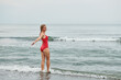 © Vyacheslav - a girl looks at the sea in a red swimsuit