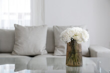 Empty Apartment With Minimal Loft Style Interior, Glass Vase With Bouquet Of Peonies On Foreground And Wall With Full Length Window On Background. Close Up, Copy Space.