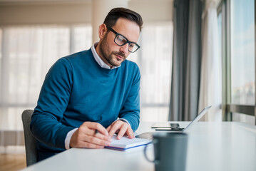 Wall Mural - serious professional making business plan while working at office desk